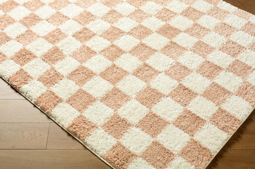 Close-up of the Bilshivtsi Area Rug. Features a textured, cream and light pink checkerboard pattern. Contemporary style. Corner