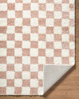 Close-up of the Bilshivtsi Area Rug, a plush, machine-woven rug with a pink and white checkerboard pattern. Fold