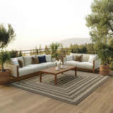 Outdoor patio scene with sofas and Nourison Tulum Brown Outdoor Area Rug.