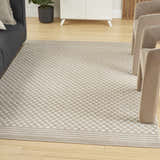 Living room scene with a beige Nourison Care Free rug featuring a modern checkerboard pattern.