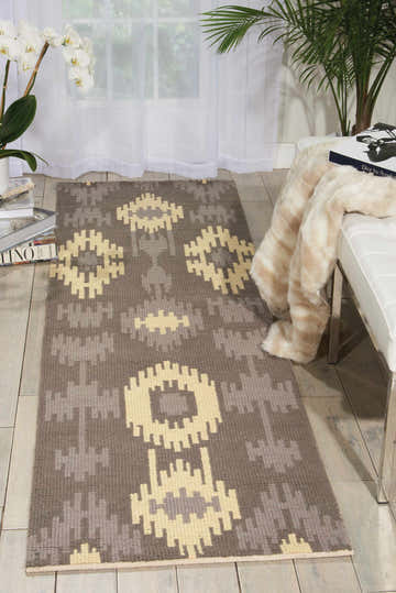 Entryway with Barclay Butera Prism Pebble rug, a gray wool runner with geometric pebble pattern. White bench, orchids, and palm.