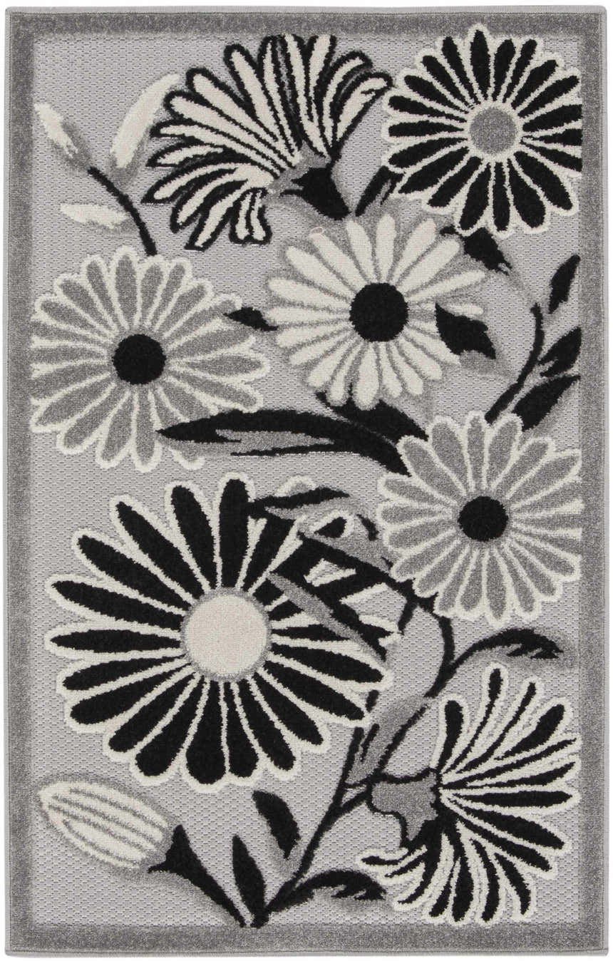 Close-up of the Nourison Aloha Black White Outdoor Area Rug featuring a floral design with black, white, and gray flowers.