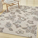 Farmhouse style room with a Nourison Aloha Beige rug, wood floors, and woven chair.