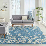 Modern living room with a gray sofa and the aqua Nourison Tranquil rug featuring a floral pattern.
