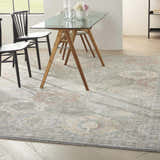 Dining room with glass table and Nourison Parisa Grey Multicolor rug, farmhouse style.