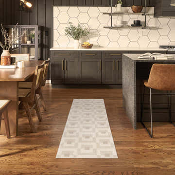 Modern kitchen with Nourison Nordic Ivory Beige runner rug, dark cabinets, wood floors, and dining table.