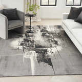 Living room scene with grey chair, white sofa, and Nourison Twilight Grey Ivory Black rug.