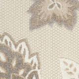 Close-up of the Nourison Aloha Beige Farmhouse Area Rug showing floral pattern and woven texture.