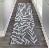 Hallway scene with Nourison Aruba Slate/Cream Beach Area Rug runner on dark wood floor, white walls and door.
