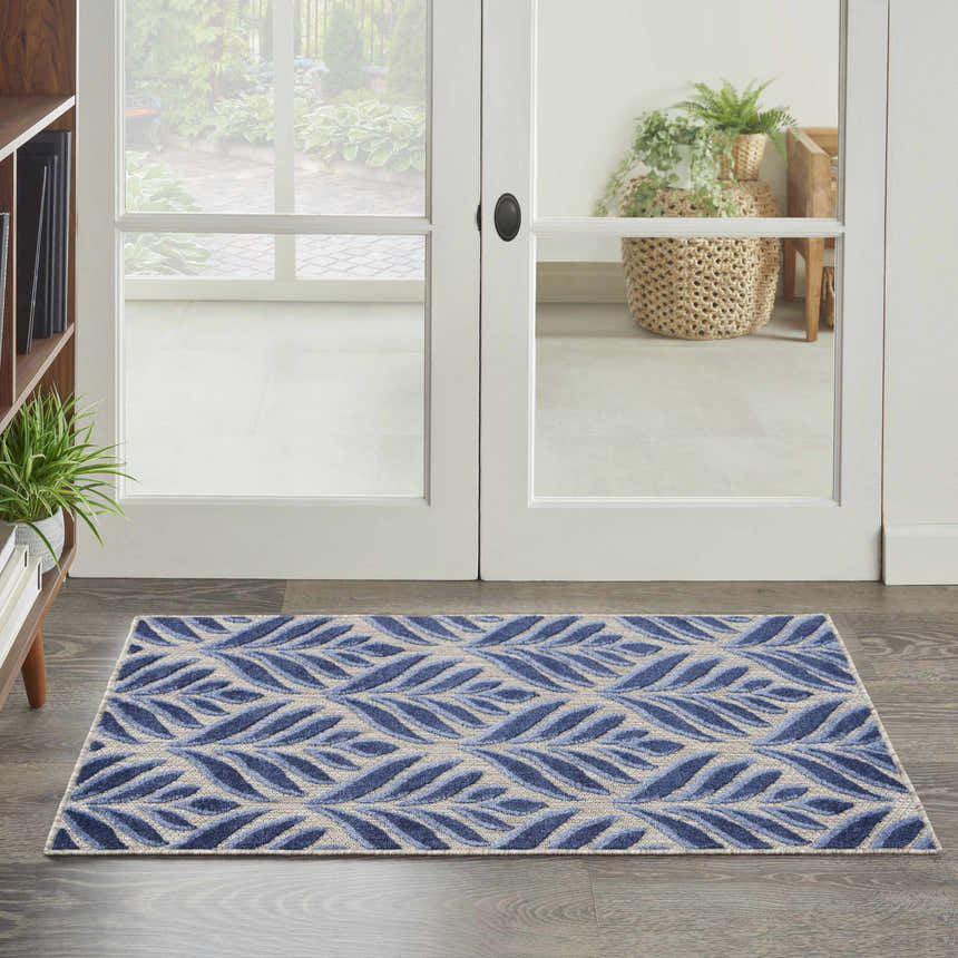 Entryway with Nourison Aloha Blue Outdoor Area Rug featuring a leaf pattern on dark wood floors.