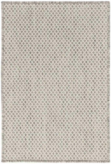 Close-up of the Nourison Courtyard Ivory Silver rug. Features a diamond pattern and fringed edges.