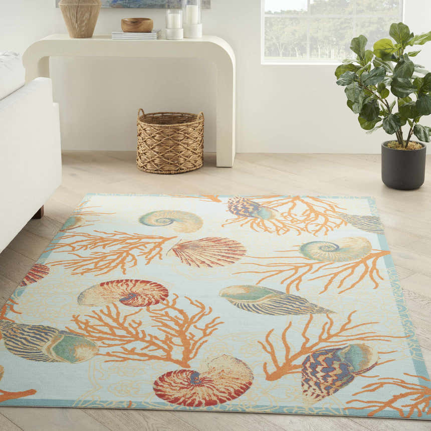 Coastal living room with Waverly Sun N' Shade Light Blue rug featuring coral and seashell design.