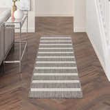 Hallway with Nourison Positano Charcoal Ivory rug runner, wood floors, console table, and neutral decor.