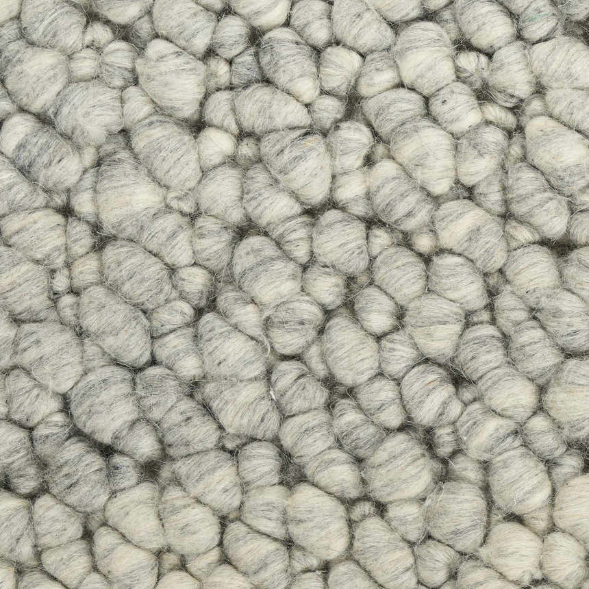 Close-up of the Calvin Klein Riverstone rug, showing its textured, grey and ivory wool pile.