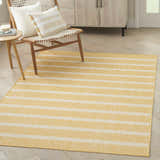 Living room scene with a Nourison Positano Yellow Ivory rug, light wood floors, chair, and cabinet.