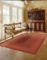 Sunroom with rustic bench and Nourison Westport Spice rug. Spice-colored wool rug adds warmth to the neutral space.