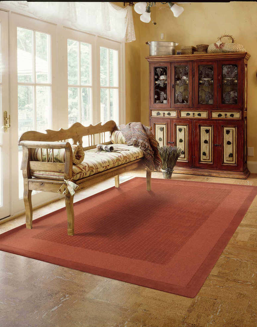 Sunroom with rustic bench and Nourison Westport Spice rug. Spice-colored wool rug adds warmth to the neutral space.