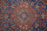 Close-up of Feizy Rawlins rug. Intricate geometric medallion design in red, tan, and blue. Farmhouse, transitional, vintage style. Texture