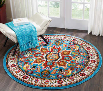 Entryway scene with round Nourison Oakdale Blue Vintage rug, white chair, and bright light from the window.
