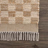 Close-up of the hand-woven Ionut Checkered Jute Area Rug, showcasing its beige and tan checkered pattern and knotted fringe detail. Swatch
