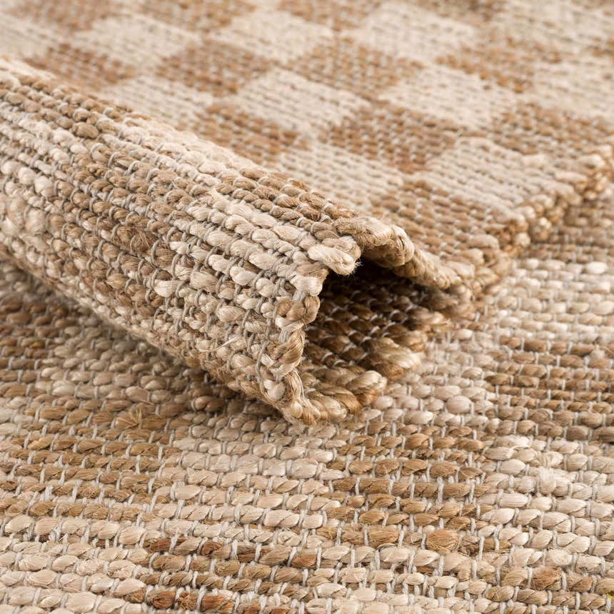 Close-up of the beige and tan checkered pattern and jute texture of the Ionut Checkered Jute Area Rug. Fold