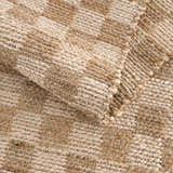 Close-up of the beige and tan Ionut Checkered Jute Area Rug, showing the woven texture and checkered pattern. Fold