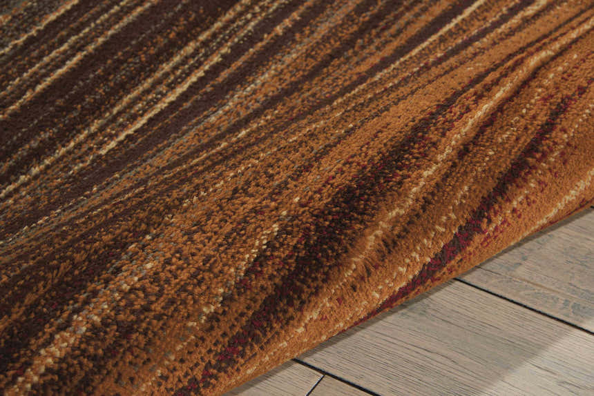 Close-up of the Nourison Paramount Multicolor Painterly rug, showcasing its brown, tan, and red stripes and textured polypropylene weave.