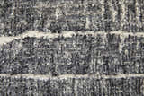 Close-up of the Feizy Kano rug, showing its black, gray, and ivory abstract design and textured pile. Texture