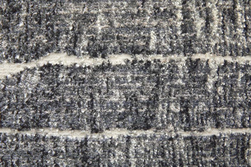 Close-up of the Feizy Kano rug, showing its black, gray, and ivory abstract design and textured pile. Texture