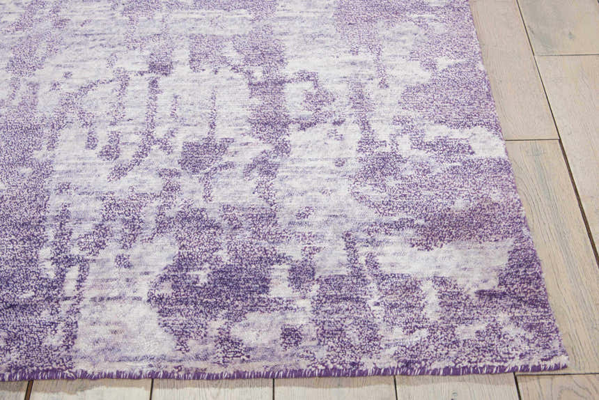 Close-up of the Nourison Silk Shadows Amethyst rug. Vintage style rug in shades of purple with distressed pattern and soft texture.
