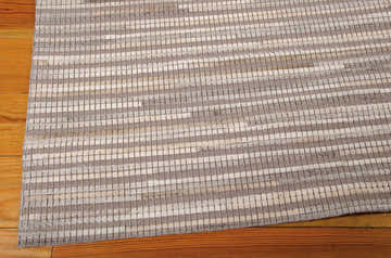 Close-up of the handmade Nourison Capelle Silver rug, with leather and wool stripes and a mid-century modern design.