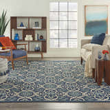 Living room scene with a Nourison Caribbean Navy Contemporary Area Rug, blue chair, and modern decor.