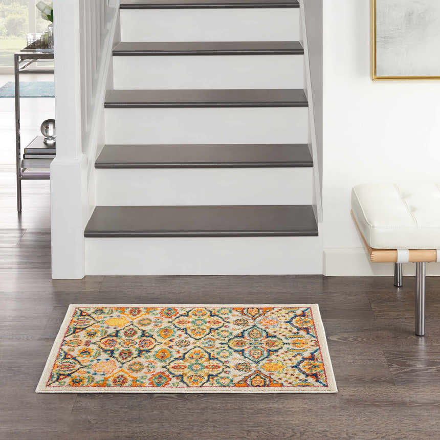 Entryway with Nourison Allur Ivory Multicolor rug, dark wood floors, white stairs, and modern white bench.