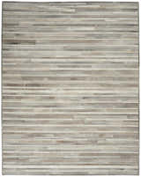 Close-up of the Calvin Klein Home Prairie Silver rug. Features a gray and silver striped pattern with a hair on hide texture.