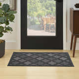 Entryway with Nourison Easy Care Charcoal Black rug, geometric pattern, black door, wood floors, and view to outdoor patio.