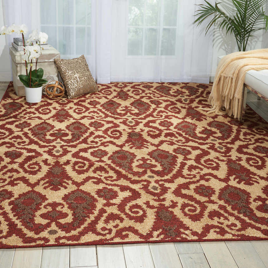 Living room scene with Nourison Kindred Ivory/Red rug, white sofa, orchids, and natural light from sheer curtains.