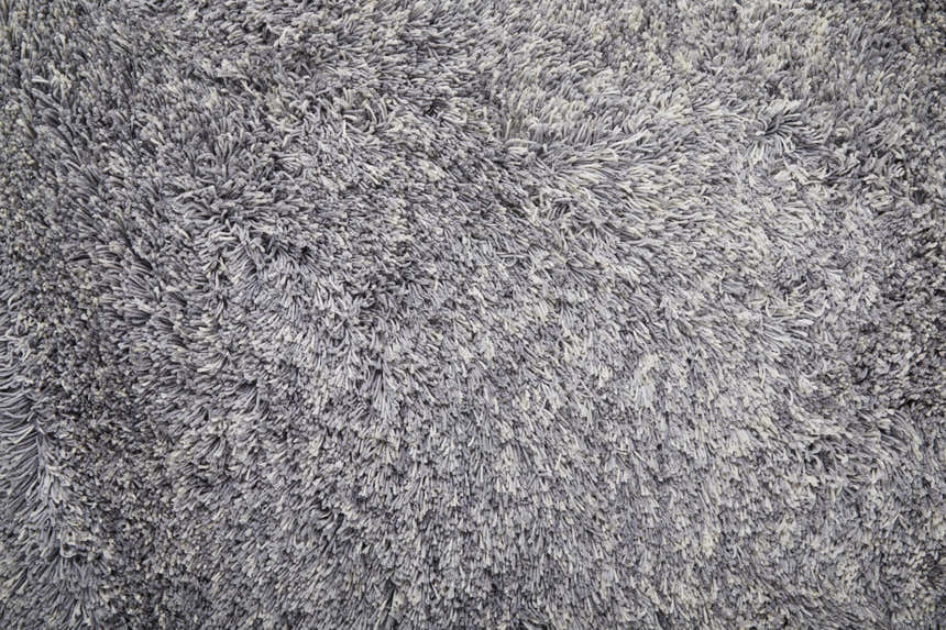Close-up of the Feizy Stoneleigh Modern Solid Area Rug in gray and silver, showing its plush, hand-tufted texture. Texture