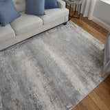 Living room scene with a Feizy Cadiz Taupe/Gray/Silver rug, white sofa, blue pillows, and wood floors. Roomscene-Rectangle