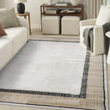 Living room with a Nourison Dekor Grey Charcoal rug, white sofa and chair, and neutral decor.