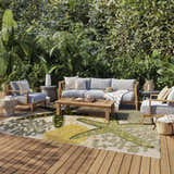 Outdoor patio scene with gray furniture and Nourison Aloha Green Yellow Outdoor Area Rug.