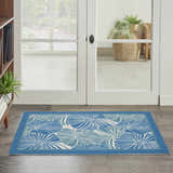 Entryway with Waverly Sun N' Shade Blue Tropical Area Rug. Light blue rug with tropical leaf pattern on wood floor.