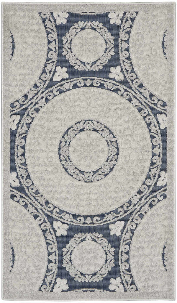 Close-up of Nourison Key Largo Blue Contemporary Area Rug. Features a circular, floral pattern in light blue and navy.