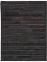 Close-up of the Calvin Klein Home Prairie Black Area Rug, featuring a handmade, horizontal hair-on-hide pattern.
