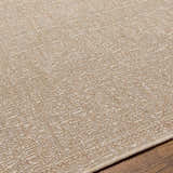 Close-up of the Vanderhoof Indoor & Outdoor Rug. Neutral light peach and mocha tones with a subtle geometric pattern. Texture
