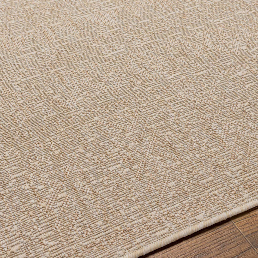 Close-up of the Vanderhoof Indoor & Outdoor Rug. Neutral light peach and mocha tones with a subtle geometric pattern. Texture