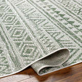 Close-up of the Novato Olive All Over Pattern Performance Rug showing its olive and gray geometric design and machine-woven texture. Fold
