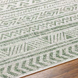 Close-up of the Novato Olive rug showing its geometric, all-over pattern in shades of olive green and gray. Texture