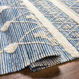 Close-up of the Eben Area Carpet showing its blue and off-white woven texture and geometric, tufted details. Fold