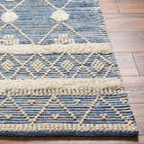 Close up of the hand woven Eben Area Carpet. Features a blue and off white bohemian pattern. Front