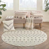 Cozy sunroom with a round Nourison Grafix Ivory/Grey Bohemian rug, tufted bench, and textured throw pillows.